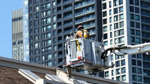 Firefighters with instruments working on the roof of condo building Stock Footage 116079683