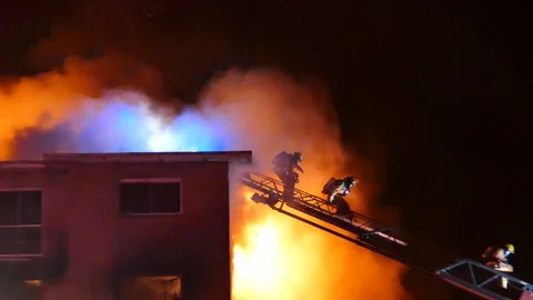 Firefighters on ladder during dramatic inferno Stock Footage 105275745