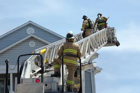 Firefighters on a ladder fire brigade emergency Stock Photos