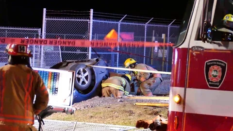 Firefighters placing plank of wood at car accident Stock Footage 102001153