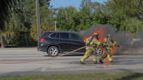 Firefighters Prepare to Extinguish Burning SUV Stock Footage 169749399