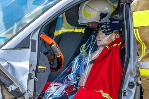 Firefighters pull a man trapped in a car after a car accident Stock Photos