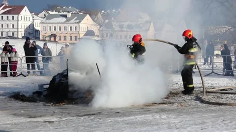 Firefighters put out a fire in a snowy town during a winter event with large cro Stock Footage 330155694