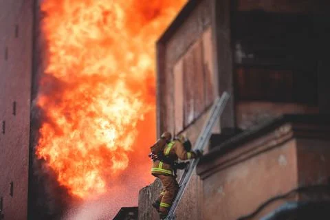 Firefighters put out large massive fire blaze, group of fire men in uniform d Stock Photos