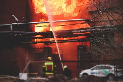 Firefighters put out large massive fire blaze, group of fire men in uniform d Stock Photos