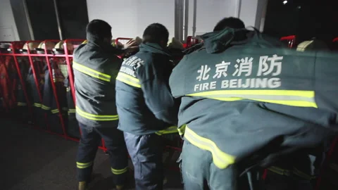 Firefighters quickly put on fire suits at night, Beijing, China Stock Footage 143003007