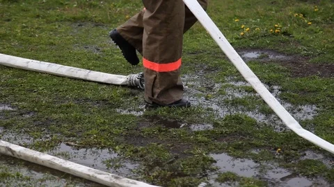 Firefighters remove fire hoses and equipment after use Stock Footage 123988358