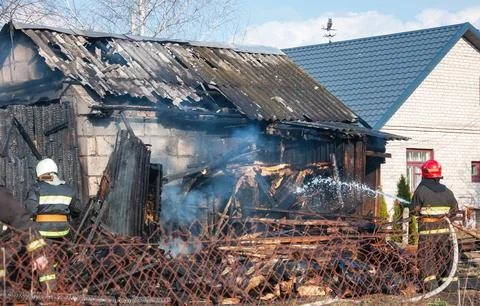Firefighters respond to a structure fire in a rural area during daytime Stock Photos