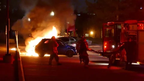 Firefighters Running To Setup Hose At Car Fire Scene Stock Footage 76755903