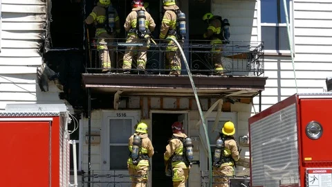 Firefighters searching inside the wall for fire during day Stock Footage 94864090