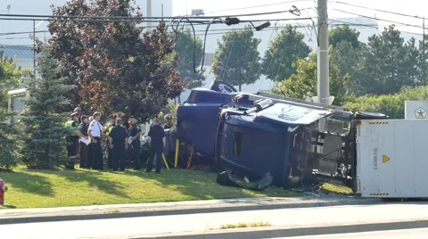 Firefighters talking with cops on the scene of a rolled over 18-wheeler Stock Footage 56870136