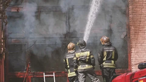 Firefighters team controlling fire with high pressure water stream Stock Footage 333122734