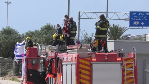 Firefighters on top of fire engine, cheering paramedics and volunteers of MDA Stock Footage 127931021