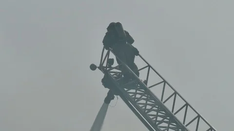 Firefighters on top of ladder working on fire Stock Footage 114769575