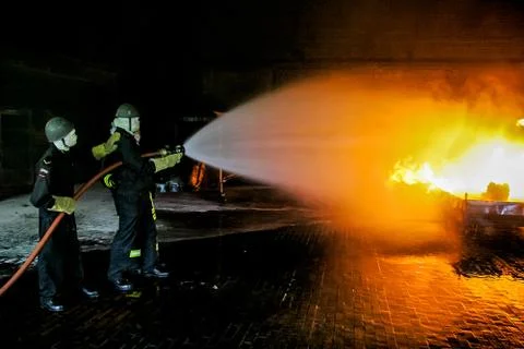 Firefighters training for fire fighting. Stock Photos