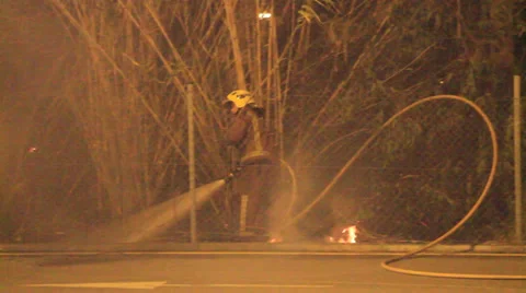 Firefighters try to douse a fire started very near of housings Stock Footage 34452038