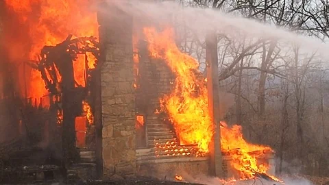Firefighters trying to control house fire Stock Footage 73432831