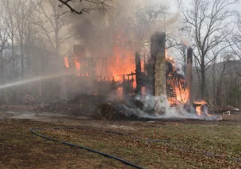 Firefighters trying to control house fire Stock Photos