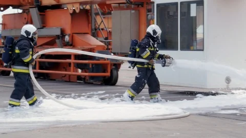 Firefighters using fire-extinguishing foam Видео 92421397