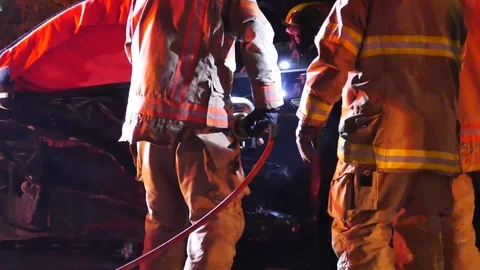 Firefighters using jaws of life at car crash at night Stock Footage 102236015