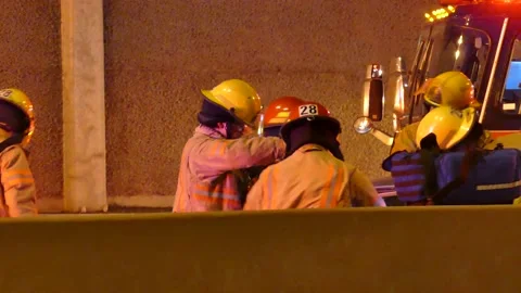 Firefighters using jaws of life on freeway accident Stock Footage 133275045