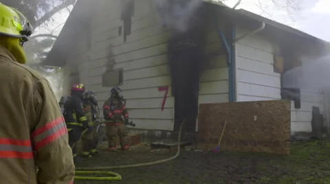 Firefighters wait outside burning house Stock Footage 60762162