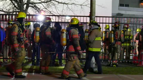 Firefighters walking at school in flames Stock Footage 139657106