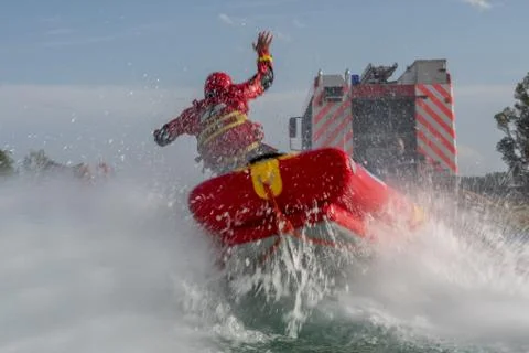 Firefighters in water rescue drill, using canoe and special suits. Stock Photos