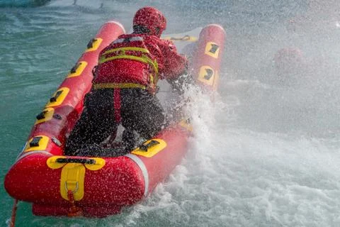 Firefighters in water rescue drill, using canoe and special suits. Aerial vie Stock Photos