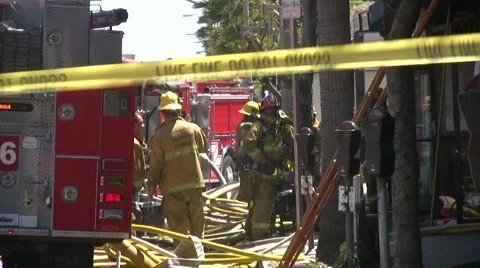 Firefighters at Work next to firetruck at a fire scene Stock Footage 5186375