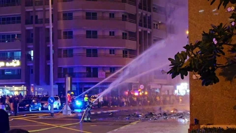 Firefighting in action. Emergency services deploy hoses to douse a street fire Stock Footage 311765295