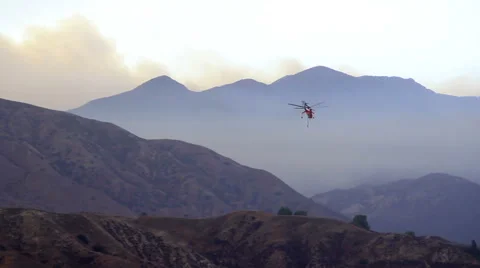 Firefighting helicopter heading into wildfire Stock Footage 66778240