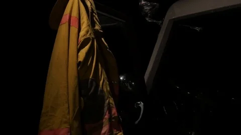 Firefighting jacket hanging on fire truck door 库存影片 77838877
