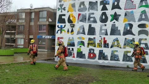 Fireifghters walking in backyard of apartment Stock Footage 139664327
