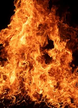 Firelight glows on black background. Firelight flames create warm texture. .. Stock Photos