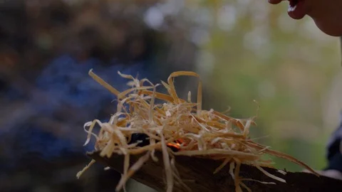 Firemaking with Burning Hay on Wood while Person blowing on it Видео 122333588