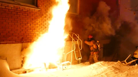 Fireman breaking apartment windows at fire with heavy flame and smoke Stock Footage 49695541