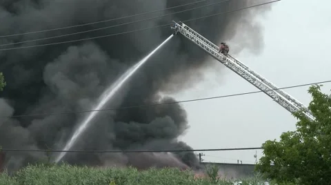 Fireman climbing ladder in front of heavy black smoke Stock Footage 40765661