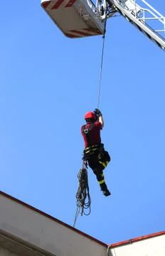Fireman down with the rope in the building during a fire alarm Fotos de archivo