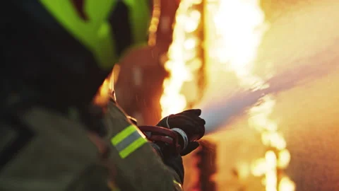Fireman extinguish fire with the hose. Burning house fire drill Vidéo 140645274