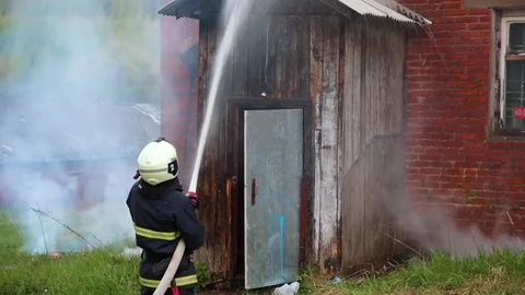 Fireman extinguish fire with water from fire hose Stock-Footage 75731957