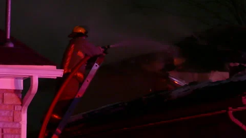 Fireman extinguish a roof fire with the ... | Stock Video | Pond5