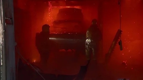 The fireman extinguishes fire in building. Burning car. Stock Footage 72913106