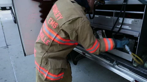 Fireman getting out the jaws of life from the fire engine Stock Footage 66548741