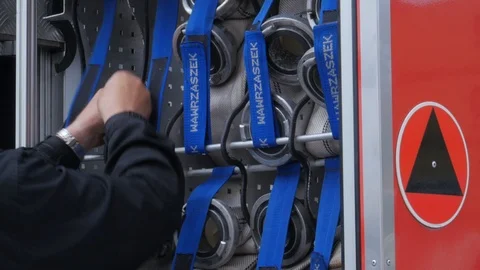 Fireman hiding fire hose to fire engine Stock Footage 92421028