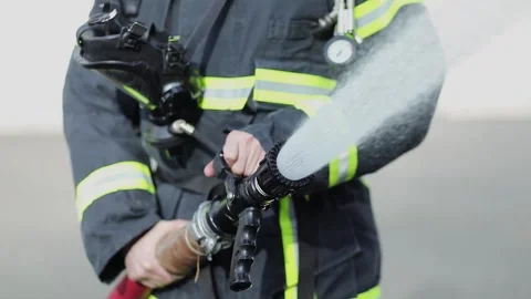 Fireman holds hose which spraying high pressure water stream Stock Footage 276368498
