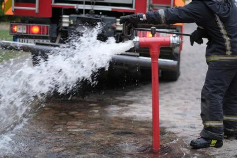 The fireman opens a fire hydrant to extinguish a fire Foto stock
