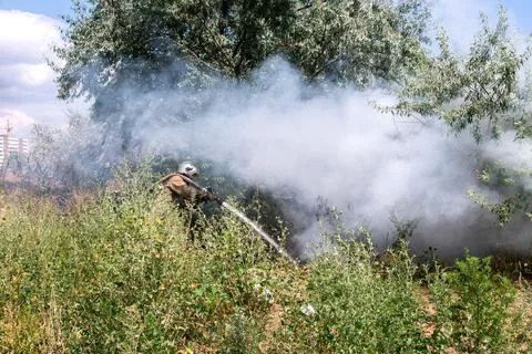 Fireman in a protective suit in a cloud of smoke under burning pressure. Stock Photos