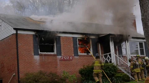 Fireman pulls burning window from house HD Stock Footage 94772360