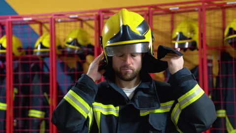 Fireman puts on a protective helmet at the fire station Stock Footage 256808065